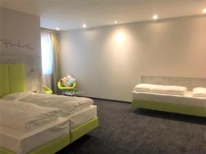 una camera con due letti e una sedia di SleepySleepy Hotel Dillingen a Dillingen an der Donau