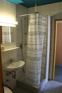 een badkamer met een douchegordijn naast een wastafel bij Gästehaus Goethe-Institut Schwäbisch Hall in Schwäbisch Hall