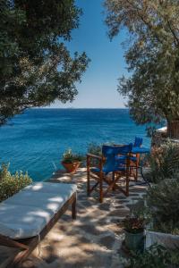 een patio met 2 stoelen en een tafel en de oceaan bij Agriolykos Pension in Agios Kirykos