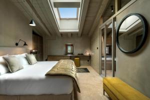 1 dormitorio con 1 cama grande y espejo en Torre del Marqués Hotel & Spa - Small Luxury Hotels, en Monroyo