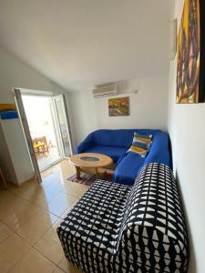 a living room with a blue couch and a table at The View in Supetar