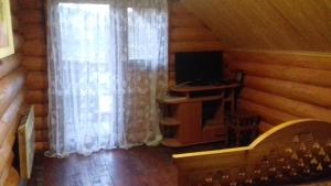 a room with a desk and a window in a log cabin at Затишний будиночок in Bukovets