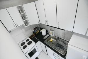 einen Blick über eine kleine Küche mit weißen Schränken in der Unterkunft Apartman Romana Duplex Divčibare in Divčibare