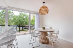 une salle à manger avec une table, des chaises et une grande fenêtre dans l'établissement Beautifully renovated appt with big cosy terrace, à Knokke-Heist