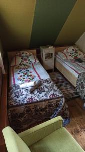 a room with two twin beds and a chair at AGROTURYSTYKA TEOSIOWO in Pobiedna