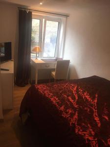 a bedroom with a bed and a desk and a window at Ferienwohnungen Blume am Schloßberg in Bad Berka