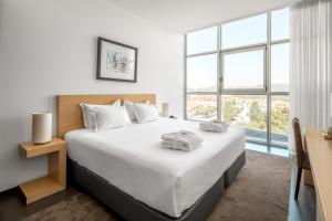 a bedroom with a large bed and a large window at Boticas Hotel Art & SPA in Boticas