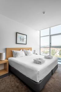 a bedroom with a large white bed with a large window at Boticas Hotel Art & SPA in Boticas