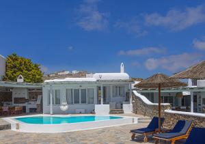 una casa con piscina y dos sillas y una sombrilla en Villa Harmony, en Kalafatis