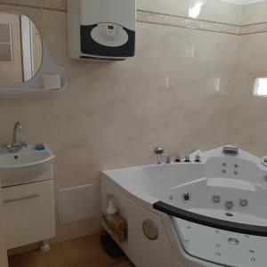 a bathroom with a white tub and a sink at Apartament wolnostojący in Augustów