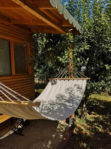 a hammock hanging from a porch of a cabin at Relax Eaza - Casa cu Hamac in Constanţa