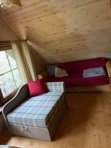 een kamer met een bed en een bank op zolder bij Šeimyninis namelis nr.2 in Kurėnai