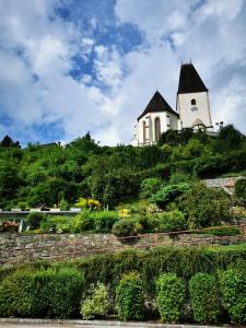 a church on top of a hill with bushes at Ferienwohnung Gabraunerhof in Pernegg an der Mur