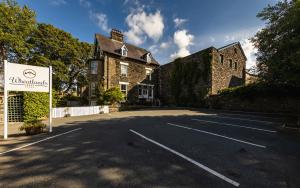 un aparcamiento vacío frente a un edificio en Wheatlands Lodge Guesthouse - Adults Only - Free car park - Licensed Venue, en Windermere