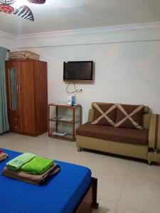 a living room with a couch and a tv at Le Barang Steakhouse & Guesthouse in Sihanoukville
