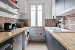 uma cozinha com uma máquina de lavar e secar roupa num balcão em Chic 1br near Paris and the Bois de Vincennes in Saint-Mandé Welkeys em Saint-Mandé