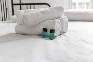 a pile of towels and bottles ofodorizers on a bed at Appartement Pouchard Welkeys in Saint-Mandé +4 photos