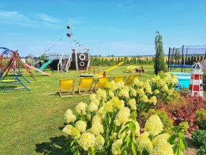 a park with a playground with chairs and a slide at Domek Standard 2 in Darłowo