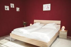 ein Schlafzimmer mit einem weißen Bett und einer roten Wand in der Unterkunft Ferienhaus Gassner in Navis