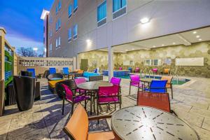 a patio with tables and chairs and a pool at La Quinta by Wyndham Waco Baylor Downtown in Waco