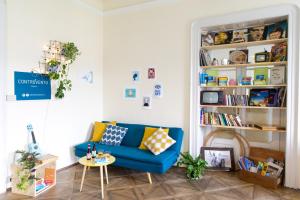 a living room with a blue couch and a book shelf at ControVento in Trieste