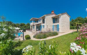 duży kamienny dom z ogródkiem z kwiatami w obiekcie Villa Sterpazzi - near Porec with Sea View, private Jacuzzi, Sauna and Pool w mieście Višnjan