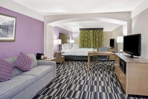 a hotel room with a bed and a couch and a television at La Quinta by Wyndham Modesto Salida in Modesto