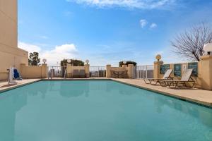 a swimming pool at a hotel with two chairs at La Quinta by Wyndham El Paso East in El Paso