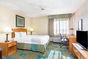 a hotel room with a bed and a desk and a television at La Quinta by Wyndham El Paso East in El Paso +22 photos