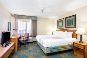 a hotel room with a bed and a desk and a television at La Quinta by Wyndham El Paso East in El Paso