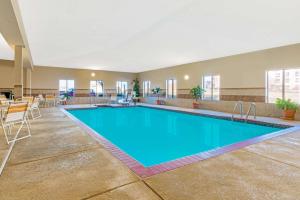 een zwembad in een grote kamer met stoelen en een tafel bij La Quinta by Wyndham Midwest City - Tinker AFB in Midwest City