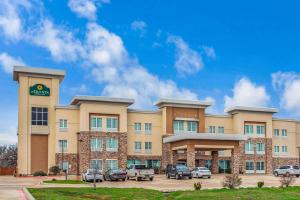 a hotel with cars parked in a parking lot at La Quinta by Wyndham Luling in Luling