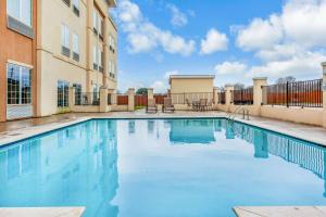 a swimming pool in the courtyard of a apartment building at La Quinta by Wyndham Luling in Luling