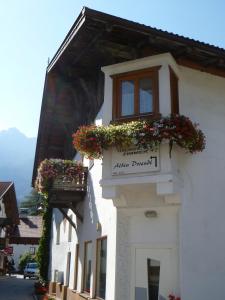 ein Gebäude mit Blumenkästen und einem Schild darauf in der Unterkunft Haus Driendl in Mieders