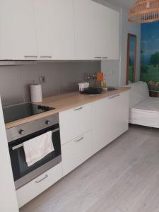 a kitchen with white cabinets and a stove top oven at Apartamento Fontinha in Porto