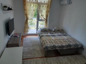 a bedroom with a bed and a window at Apartman Lipa in Bar
