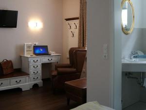 Camera dotata di scrivania con computer portatile e sedia. di Hotel Rauch ad Attendorn