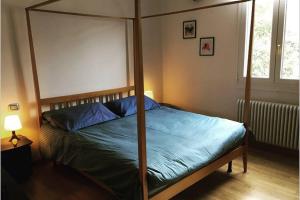 una camera con letto a baldacchino e lenzuola blu di House Bologna Stazione Mazzini flat x 2 a Bologna