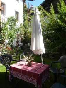 einen Tisch mit einem weißen Regenschirm und einem Kleid darauf in der Unterkunft Haus Driendl in Mieders