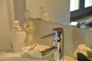 a bathroom sink with a faucet and a mirror at La Corte dei Limoni in Caprino Veronese +51 photos