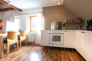 a kitchen with white cabinets and a table with chairs at Das Nest am Park in Lemgo