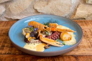 a blue plate of food with carrots and other vegetables at Romantik Hotel Chalet am Kiental in Herrsching am Ammersee