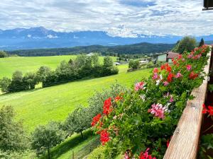 a garden with flowers and mountains in the background at Pleschinhof in Velden am Wörthersee