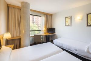 Una habitación de hotel con dos camas y un escritorio. en RICE Bulevar, en Burgos 37 fotos más