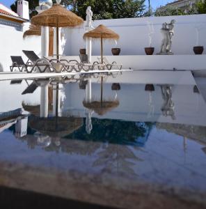 a reflection of chairs and umbrellas in the water at HOTEL S - ALOJAMENTO LOCAL in Castro Verde