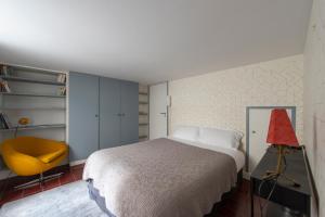 1 dormitorio con 1 cama y 1 silla amarilla en Pavleo, en París