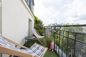 a balcony with chairs and a view of the city at Piaf in Paris