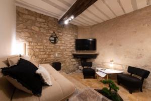 a living room with a couch and a stone wall at Pierre à Feu in Paris