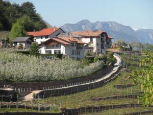 a village on a hill with houses and a road at Agritur Maso Pomarolli in Giovo