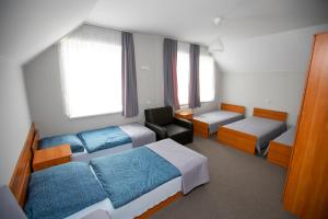 a small room with two beds and a chair at Noclegi Cristal in Malbork